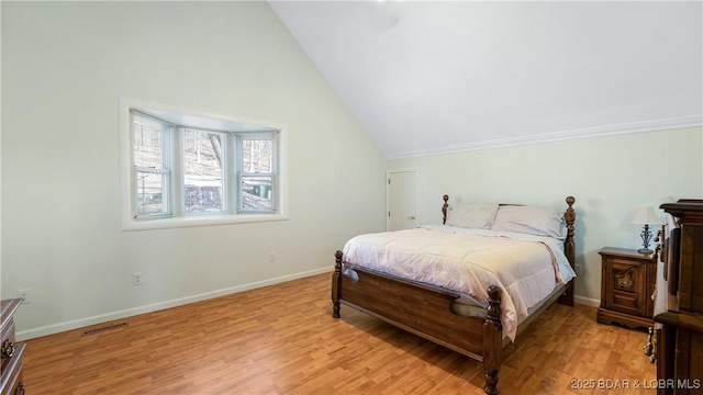 bedroom featuring visible vents, vaulted ceiling, light wood-style flooring, and baseboards