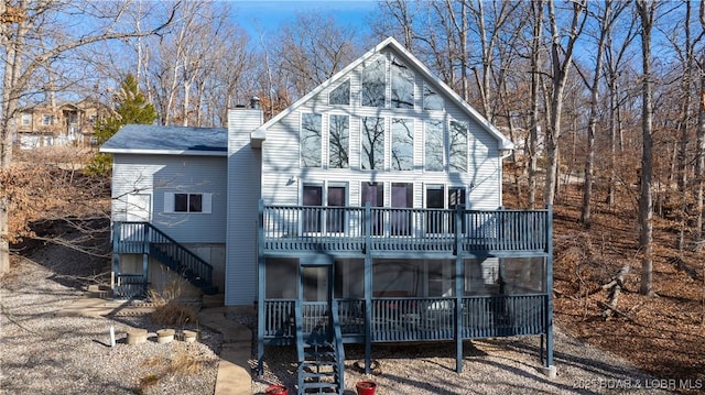 rear view of property featuring stairs and a chimney