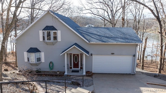 rustic home with roof with shingles, driveway, and an attached garage