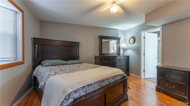 bedroom featuring ceiling fan, light wood-style flooring, and baseboards