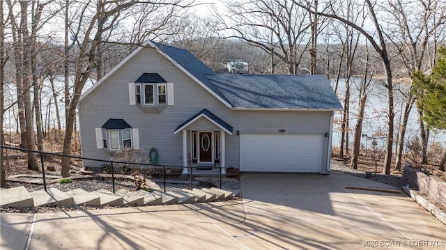 view of front facade with a garage, concrete driveway, roof with shingles, and fence