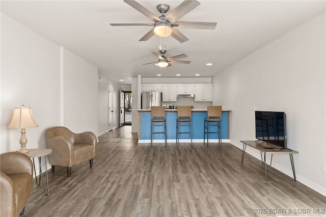 living area featuring baseboards, ceiling fan, recessed lighting, and wood finished floors