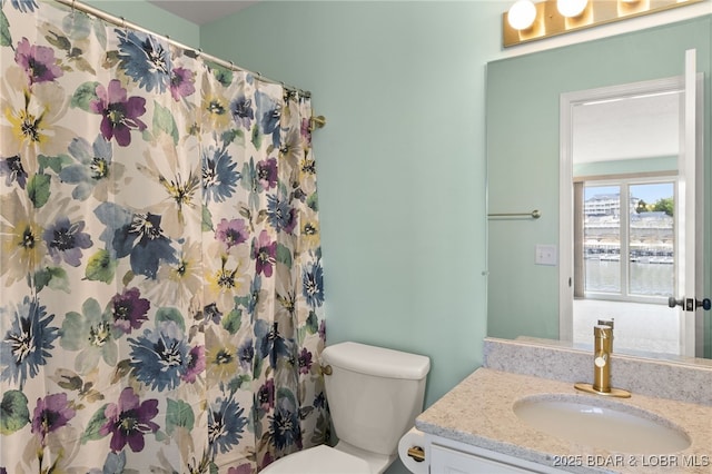 full bath featuring vanity, a shower with curtain, and toilet