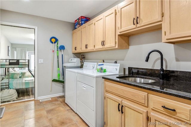 laundry area with a sink, visible vents, baseboards, cabinet space, and washer and clothes dryer