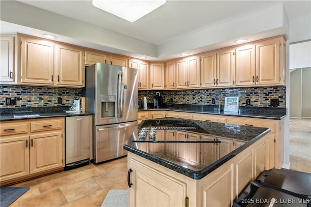 kitchen featuring stainless steel appliances, light brown cabinets, and decorative backsplash