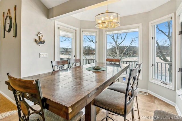 dining area featuring a healthy amount of sunlight, a notable chandelier, and baseboards