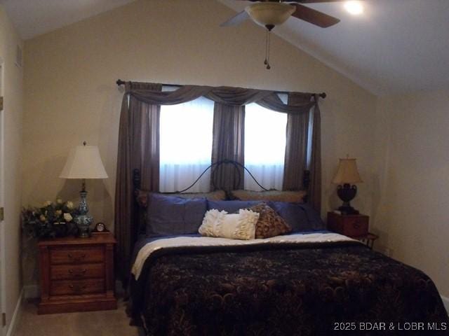 bedroom with light carpet, a ceiling fan, and vaulted ceiling