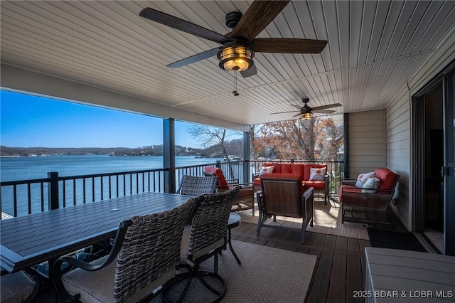 wooden terrace with outdoor dining space, a water view, ceiling fan, and an outdoor living space