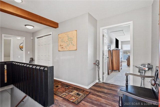 hall with dark wood-style floors, beamed ceiling, and baseboards