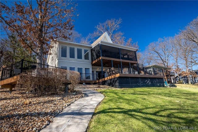 rear view of house with a sunroom, a yard, and a deck