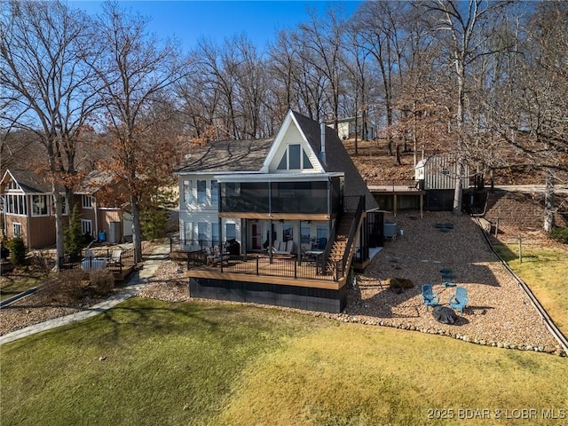 rear view of property featuring a sunroom, a yard, and a deck