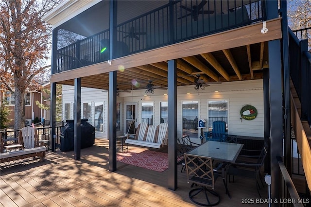 wooden terrace with ceiling fan, outdoor dining space, and area for grilling