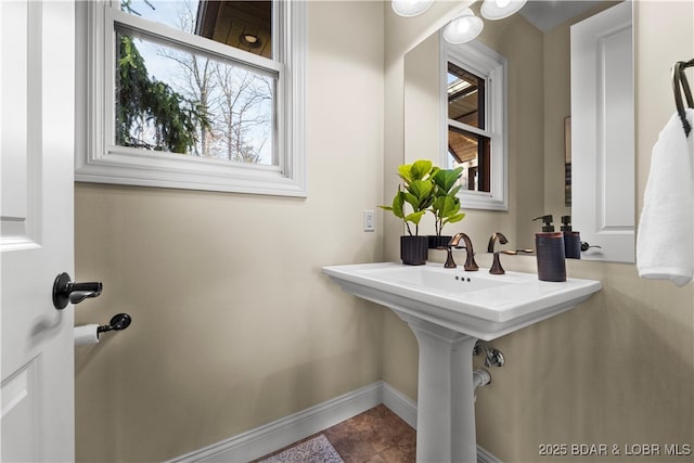 bathroom featuring tile patterned floors, a healthy amount of sunlight, and baseboards