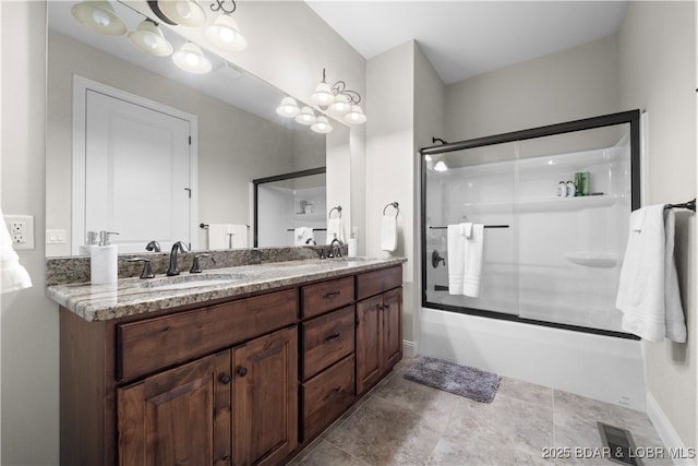 full bathroom featuring double vanity, enclosed tub / shower combo, baseboards, and a sink