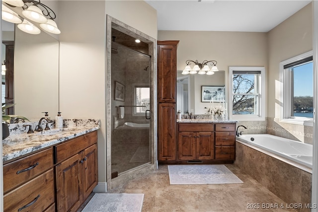 full bath with two vanities, a shower stall, a garden tub, and a sink