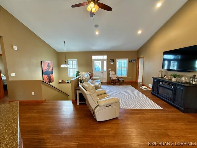 living room featuring high vaulted ceiling, plenty of natural light, and wood finished floors