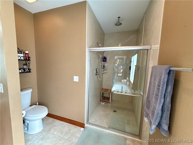 bathroom with a stall shower, tile patterned flooring, baseboards, and toilet