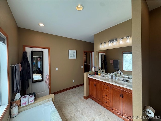 full bathroom featuring double vanity, baseboards, tile patterned floors, a washtub, and a sink