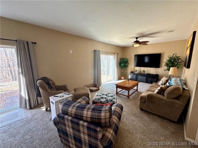 carpeted living area with ceiling fan