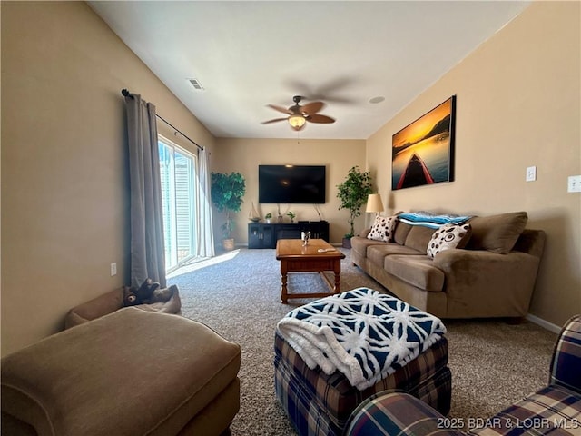 carpeted living area featuring visible vents and a ceiling fan