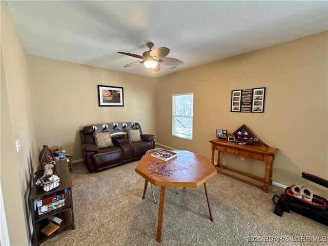 carpeted living area featuring a ceiling fan and baseboards