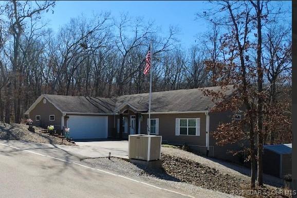 ranch-style house with a garage and aphalt driveway