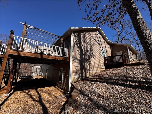 view of home's exterior with dirt driveway, a carport, and a wooden deck