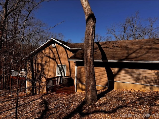 view of side of property featuring a shingled roof