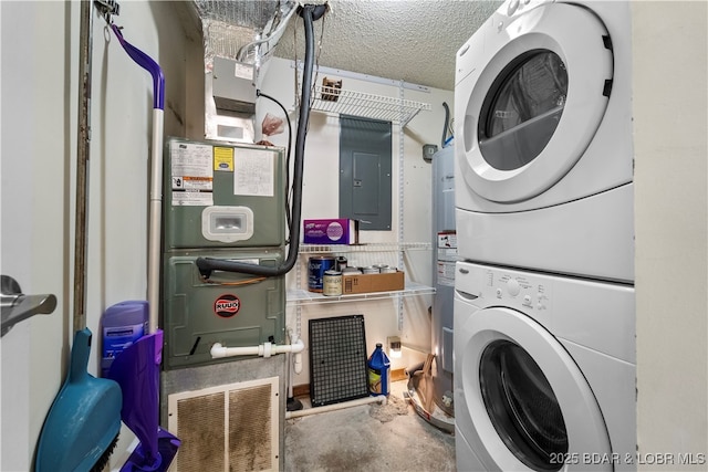 washroom with laundry area, electric panel, stacked washer and dryer, and a textured ceiling