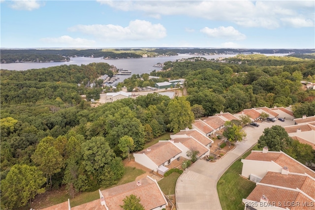 aerial view featuring a forest view and a water view