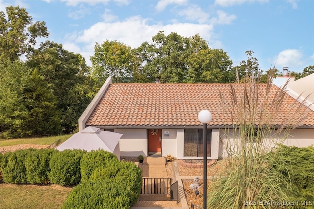 view of front of property featuring a tiled roof and stucco siding