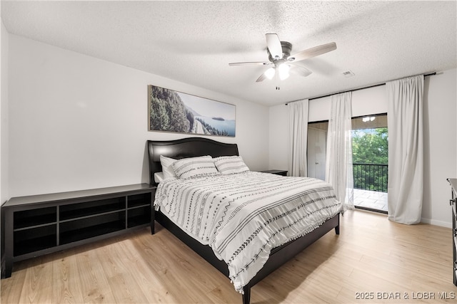 bedroom featuring a ceiling fan, access to outside, a textured ceiling, and wood finished floors