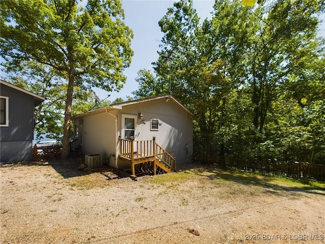 back of house featuring central AC unit and fence