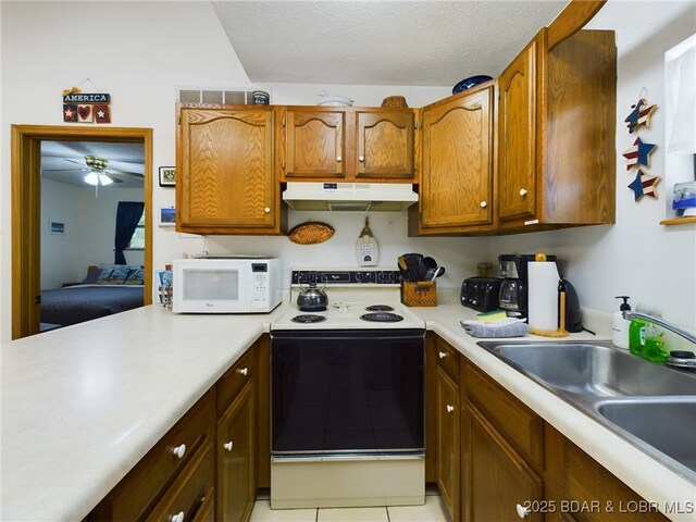 26509 Mesa Dr, Rocky Mount, MO 65072 - kitchen featuring white appliances, under cabinet range hood, light countertops, a ceiling fan, and brown cabinets