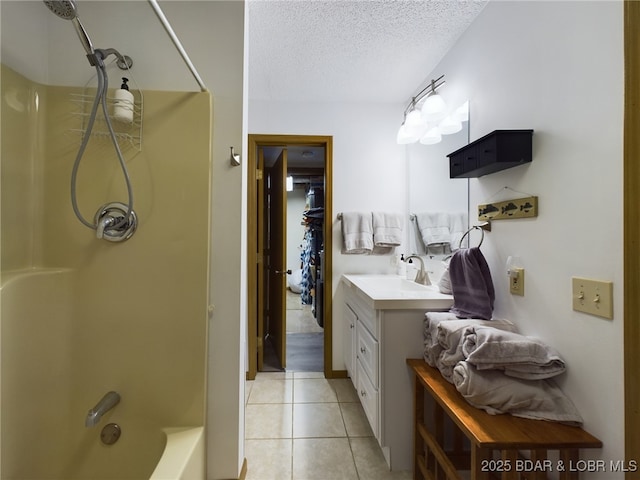 bathroom with tile patterned flooring, vanity, bathtub / shower combination, and a textured ceiling