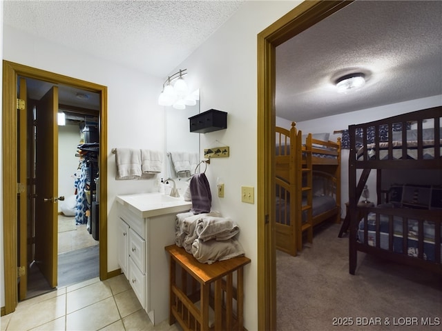 bathroom with tile patterned floors, a textured ceiling, and vanity