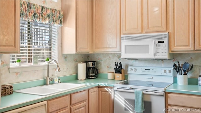 kitchen with light brown cabinets, white appliances, light countertops, and a sink