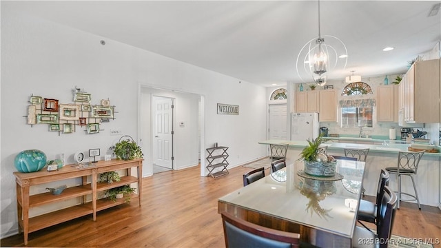 dining area with a notable chandelier and light wood-style floors