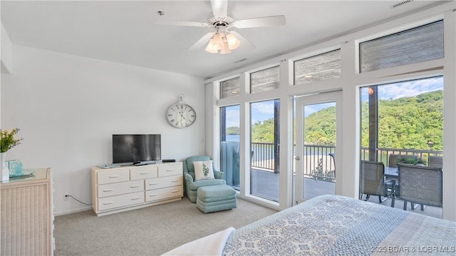 carpeted bedroom with visible vents, baseboards, ceiling fan, and access to outside