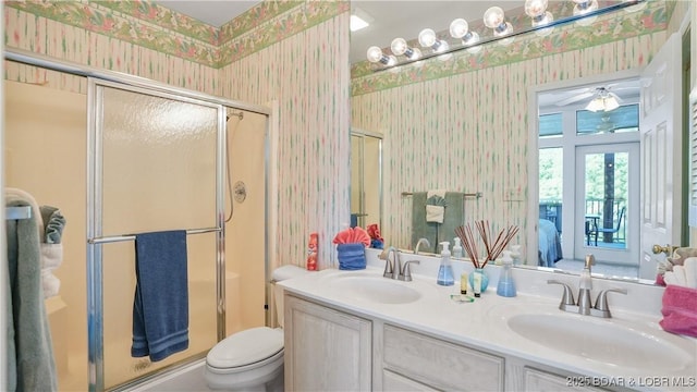 bathroom featuring a shower stall, wallpapered walls, and a sink