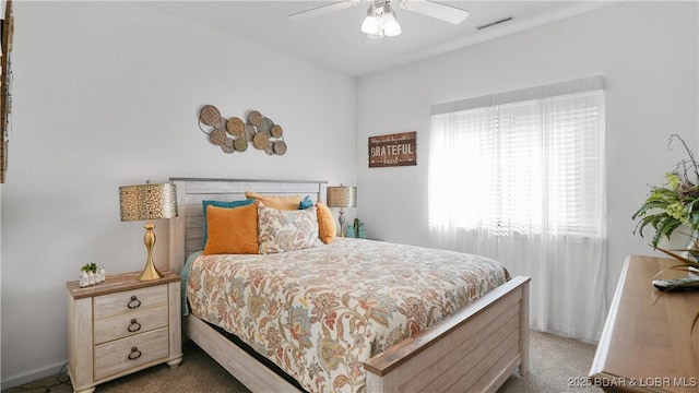 carpeted bedroom with baseboards, visible vents, and ceiling fan