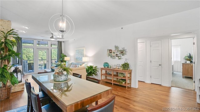 dining room with ceiling fan with notable chandelier and light wood-type flooring