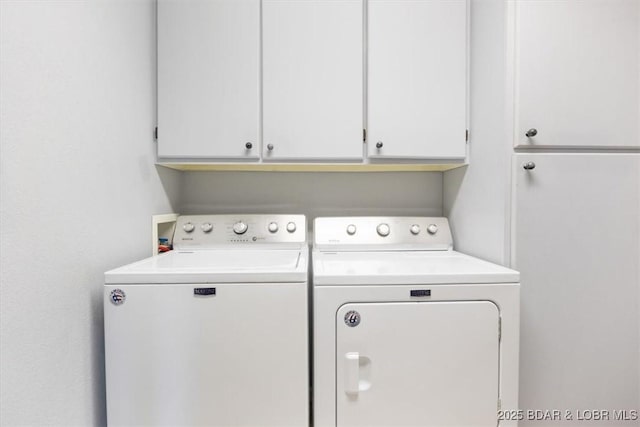 clothes washing area featuring cabinet space and separate washer and dryer