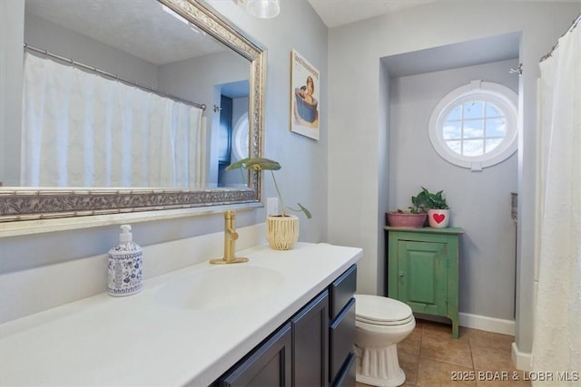 bathroom featuring tile patterned flooring, toilet, vanity, and baseboards