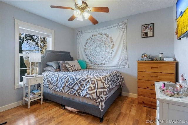 bedroom with ceiling fan, baseboards, and wood finished floors