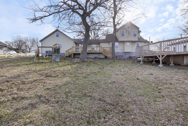 rear view of property with a playground and a deck