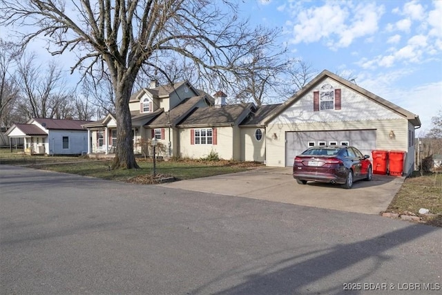 view of front facade featuring a residential view, driveway, a chimney, and a garage