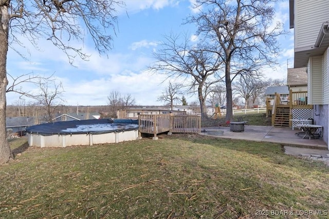 view of yard with a covered pool, a patio, stairway, and a wooden deck