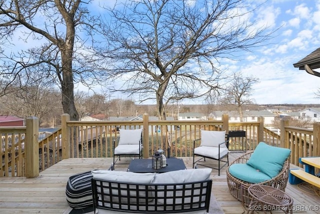 wooden terrace with an outdoor living space