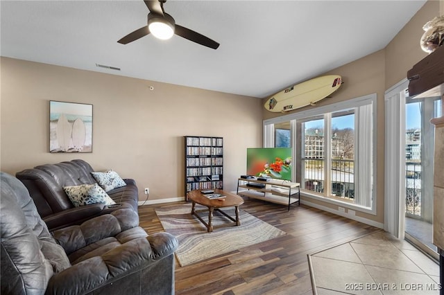 living room with ceiling fan, wood finished floors, visible vents, and baseboards